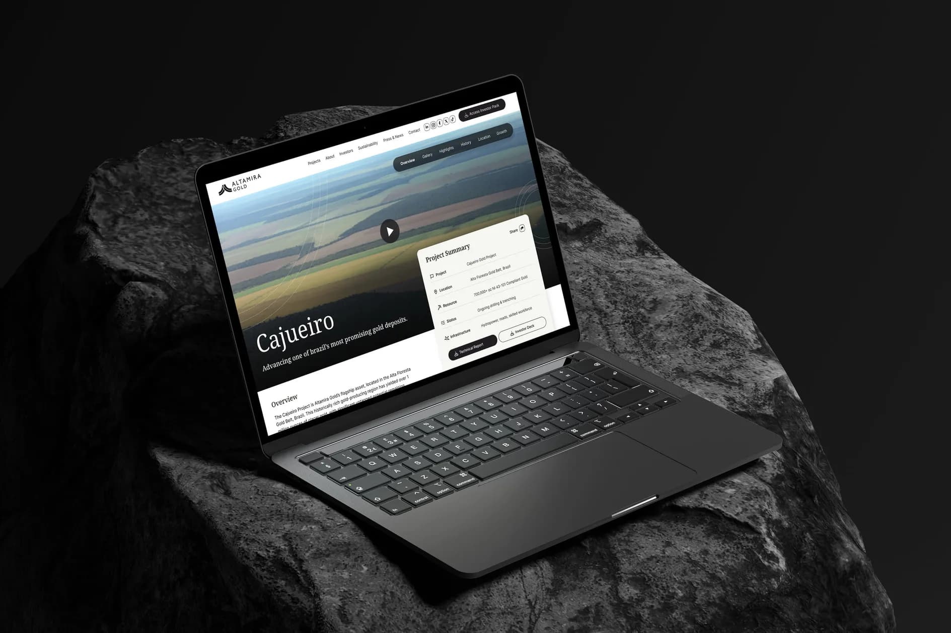 The Cajueiro project page open on a MacBook on a black rock against black: the aerial film, the project summary card, the navigation and the overview