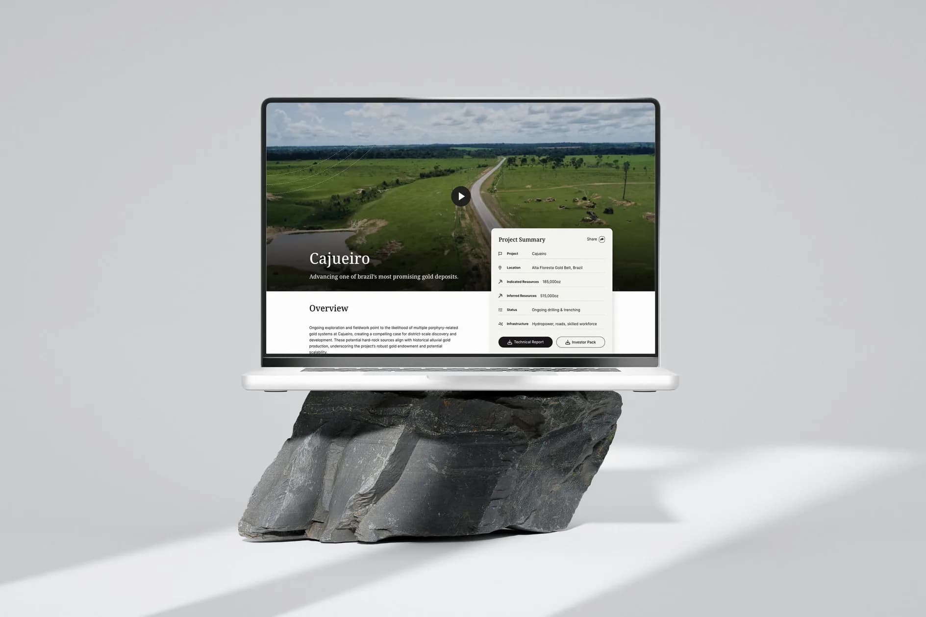 The Cajueiro project page on a MacBook on a grey rock: the aerial film with the road, the project summary card with the indicated and inferred resources, the overview