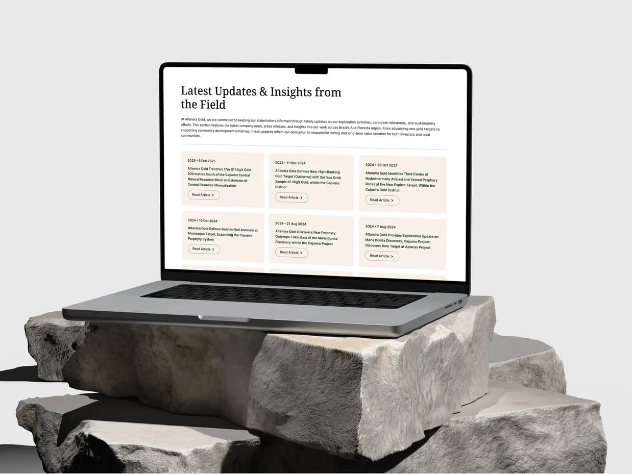 The News and Press page on a MacBook on a stack of pale stone: Latest Updates and Insights from the Field over a grid of dated releases
