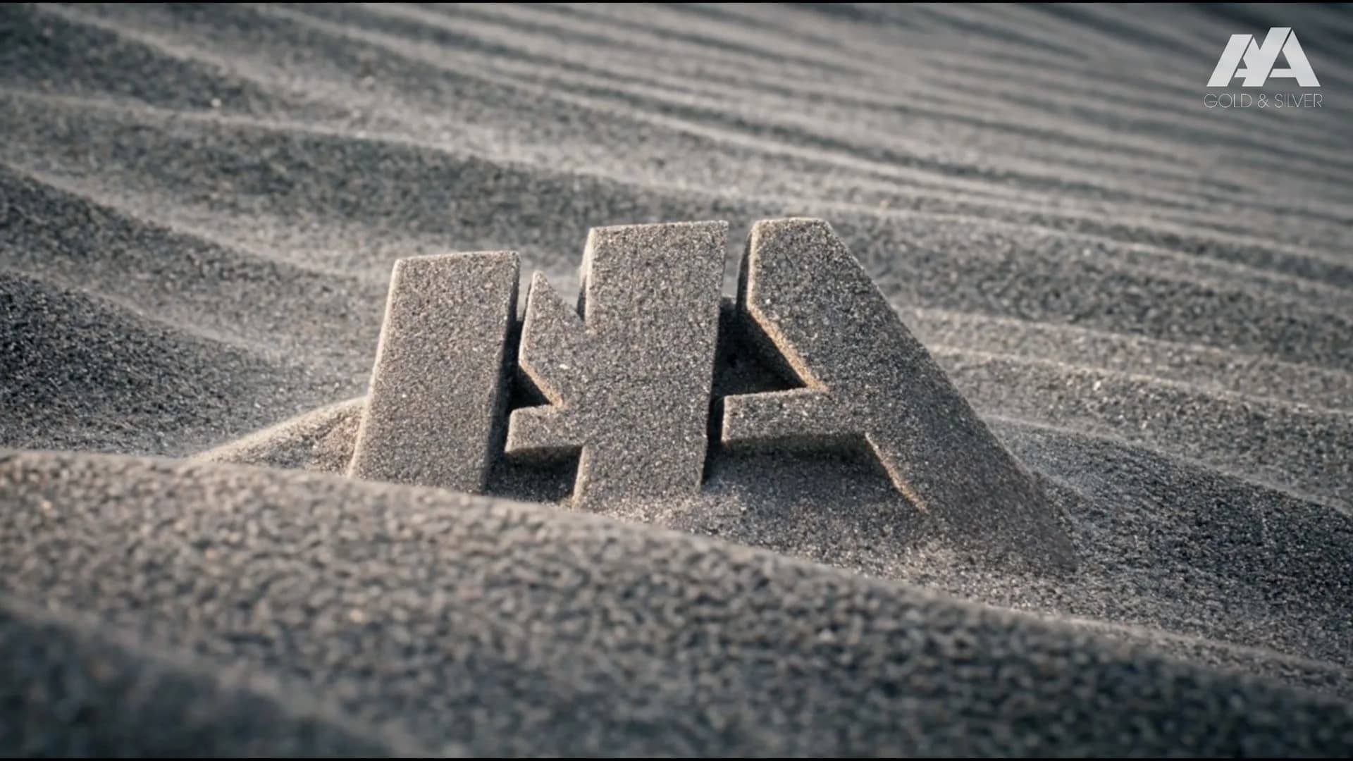 The Aya Gold and Silver mark standing in rippled silver sand: the end card of The Silver Kingdom