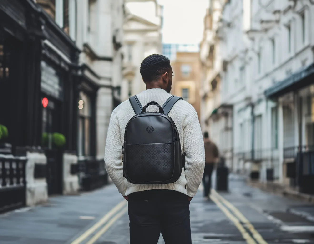 A black leather backpack with the emblem and the pattern panel, on a London street
