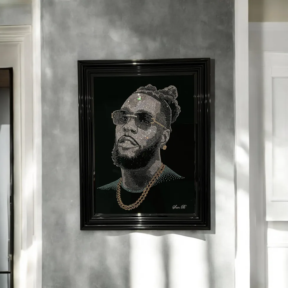 Burna Boy in crystal, framed on a grey wall in sunlight