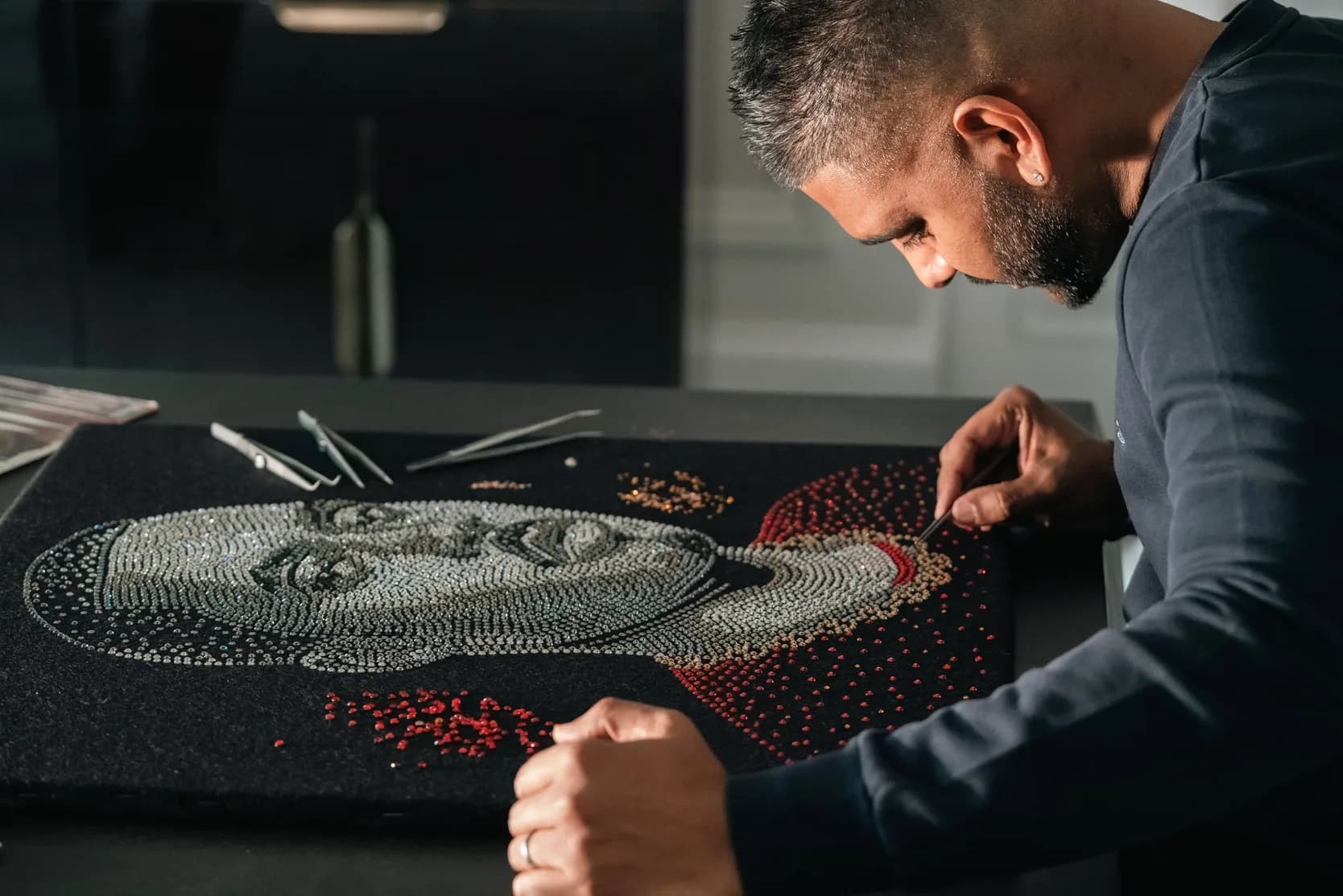 San B leaning over the board, placing red crystals