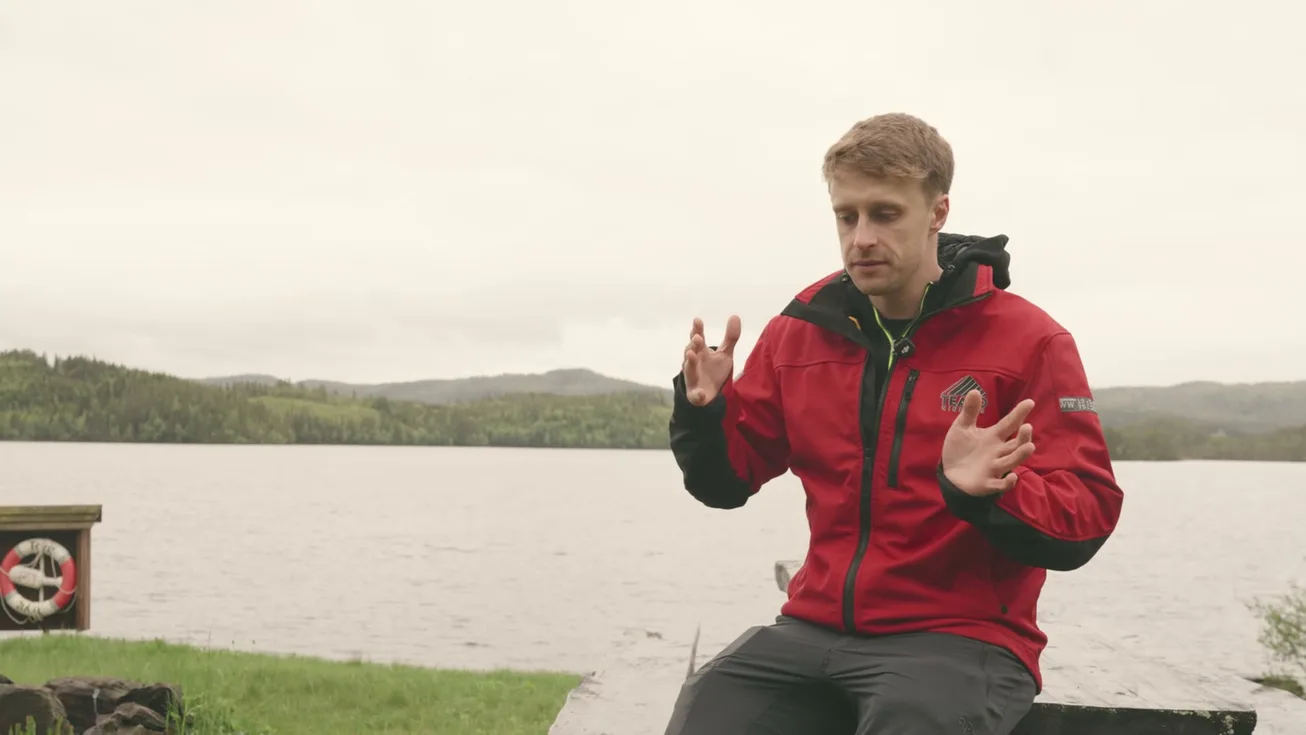 An interview at the lakeside in a red jacket