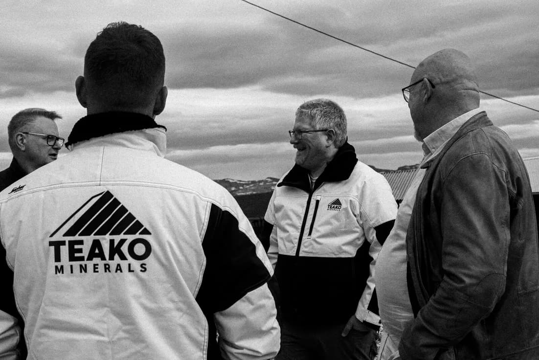 The mark on the back of a jacket, the group talking at the shore, in black and white.