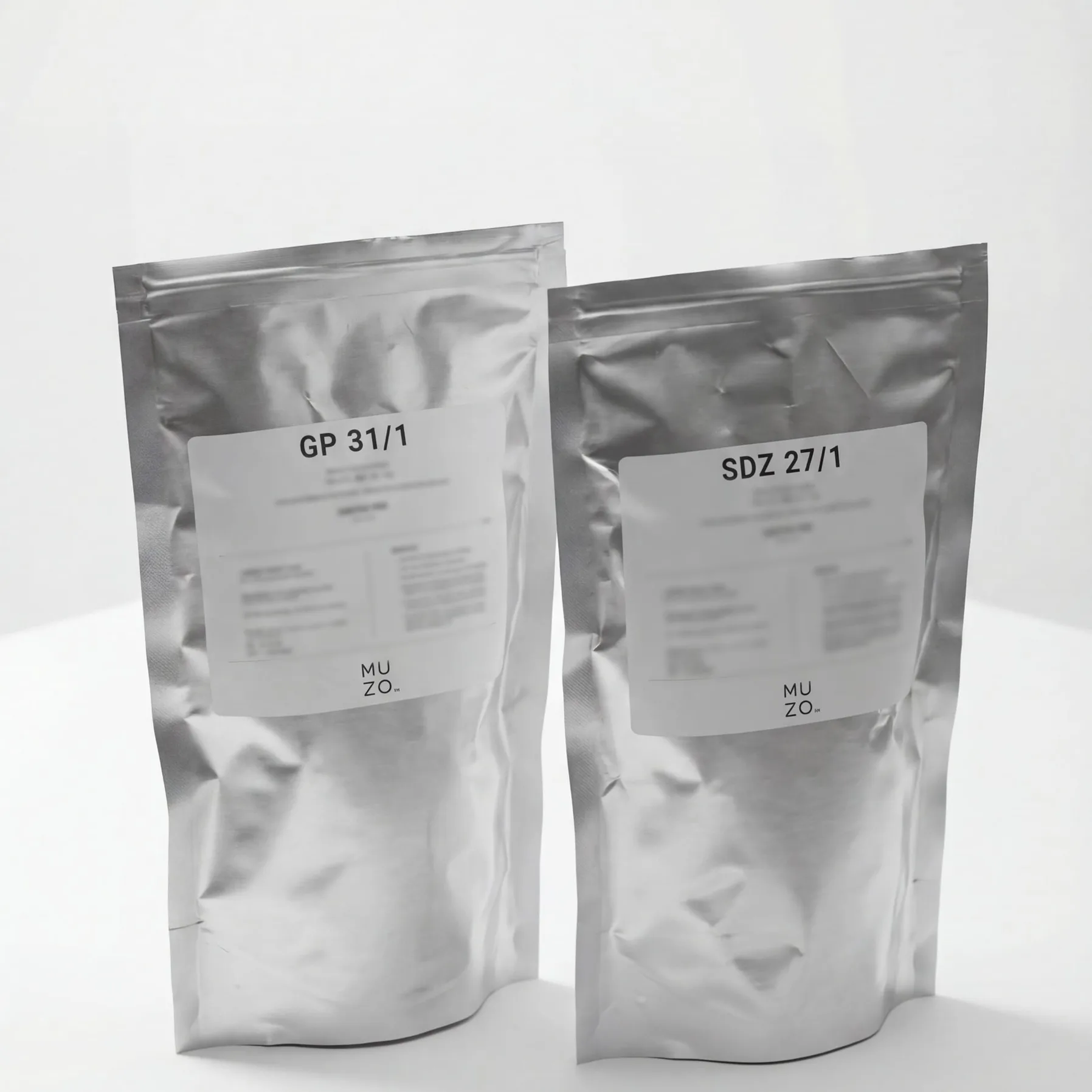 Two sealed silver MUZO packs on a white plinth, labelled GP 31/1 and SDZ 27/1
